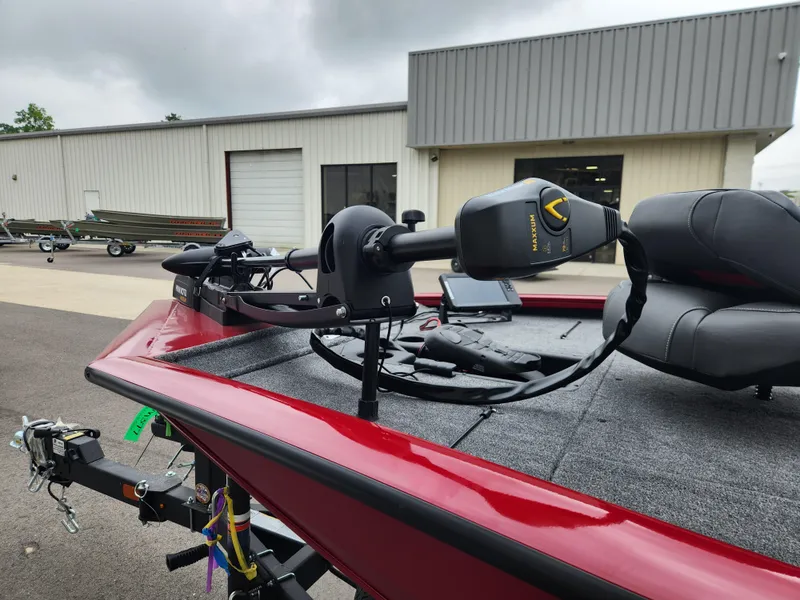 Slide: The Image of 2026 Tracker Pro Team 195 boat with trolling motor, parked outside a warehouse. - 7