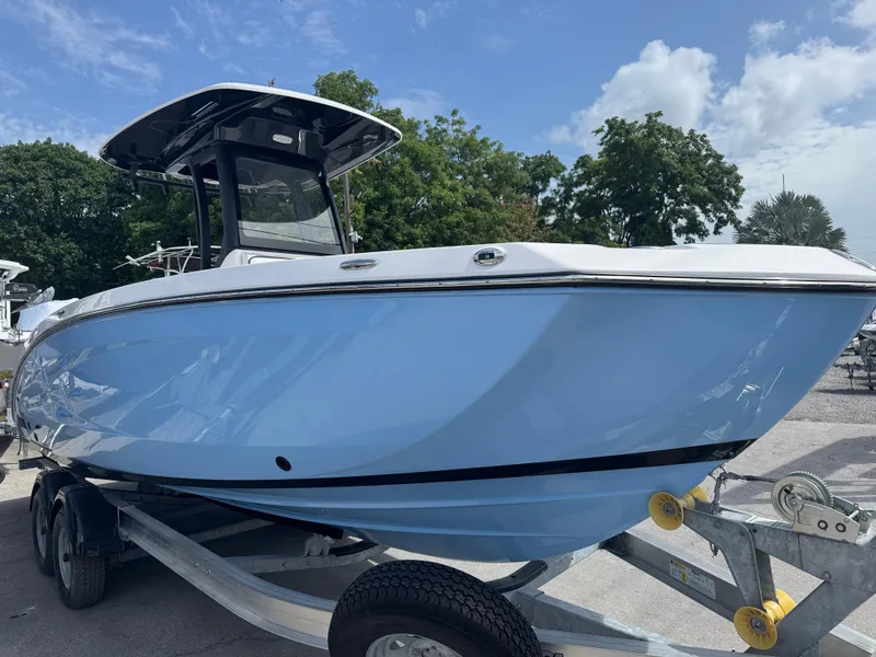 Slide: The Image of 2024 Yamaha Boats 255 FSH Sport E in light blue on trailer, outdoors. - 1