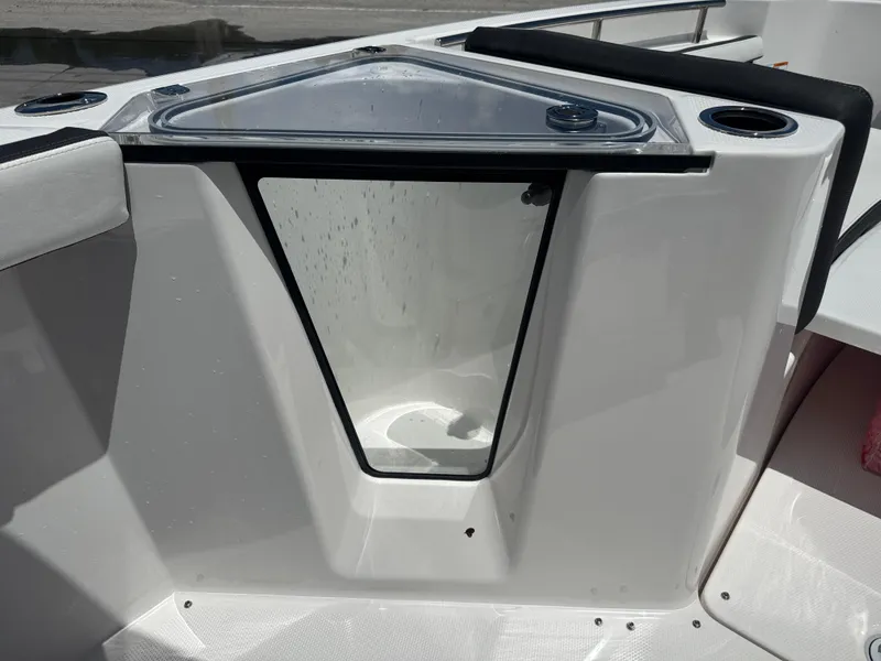 Slide: The Image of 2024 Yamaha Boats 255 FSH Sport E interior detail with storage compartment and cup holders. - 16