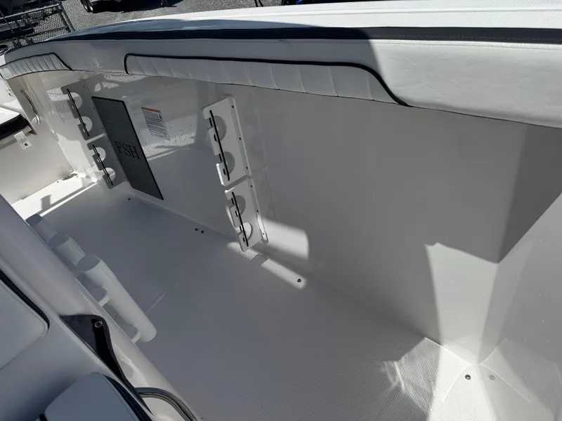 Slide: The Image of 2024 Yamaha Boats 255 FSH Sport E interior, featuring sleek white seating and storage compartments. - 19