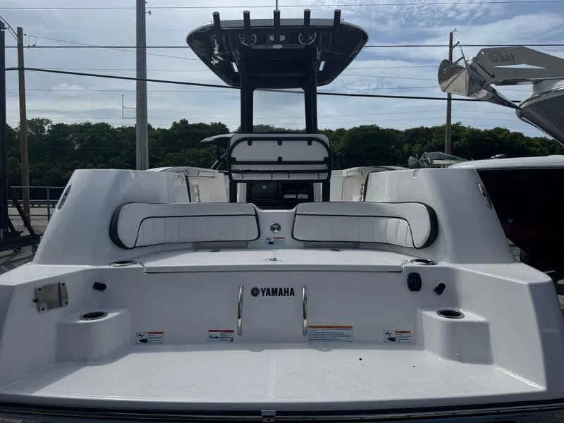 Slide: The Image of 2024 Yamaha Boats 255 FSH Sport E, rear view, showcasing seating and deck features. - 2