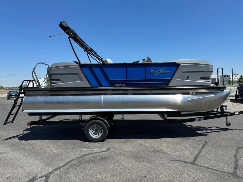 The Image of 2026 SunChaser Lucerne 20 LR DH pontoon boat on trailer, under clear blue sky. - 0