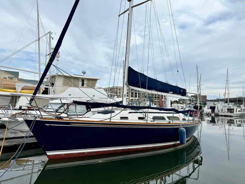 Slide: The Image of Sailboat Sabre 362, 1998 model, docked in a marina with calm waters. - 0