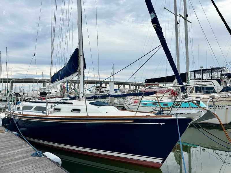 Slide: The Image of 1998 Sabre 362 sailboat docked in a marina, surrounded by other boats. - 1