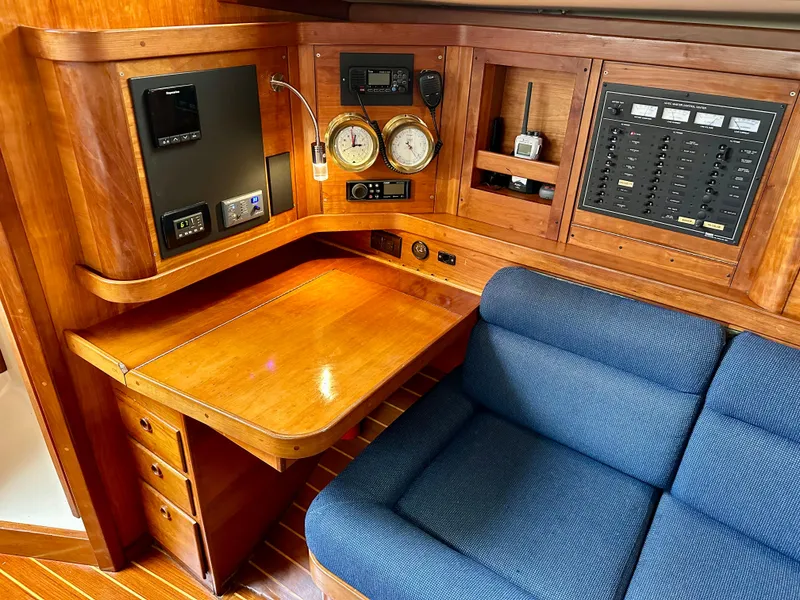 Slide: The Image of Navigation station in 1998 Sabre 362 yacht with wooden desk, blue sofa, and control panels. - 16