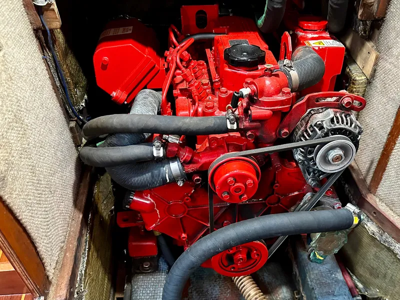 Slide: The Image of Red engine inside a 1998 Sabre 362 sailboat, featuring hoses and alternator. - 21