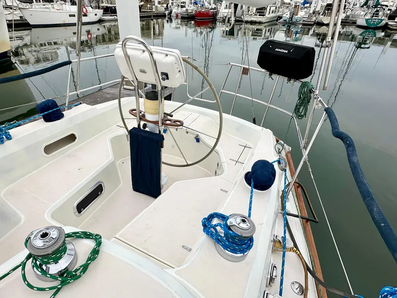 Slide: The Image of Sailboat cockpit of 1998 Sabre 362, featuring steering wheel and winches, docked in marina. - 6