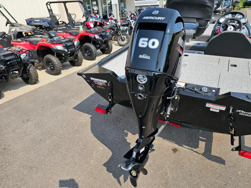 Slide: The Image of 2023 Tracker Pro Team 175 TXW boat with Mercury 60 outboard motor, parked near ATVs. - 7