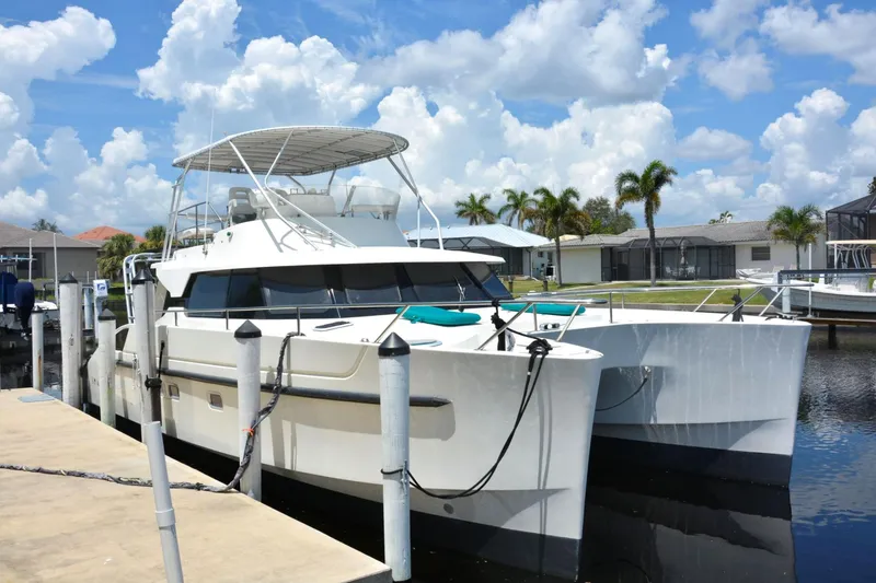 Slide: The Image of 2000 Fountaine Pajot Maryland 37 catamaran docked under a sunny sky. - 2