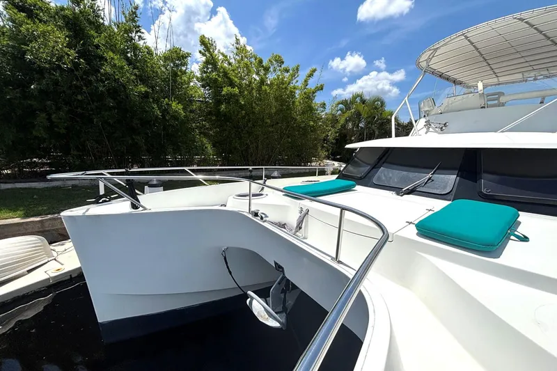 Slide: The Image of 2000 Fountaine Pajot Maryland 37 yacht with teal cushions, docked under a sunny sky. - 20