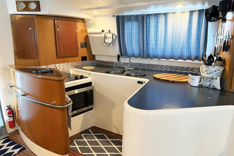 Slide: The Image of Modern kitchen interior of 2000 Fountaine Pajot Maryland 37 yacht, featuring wood cabinetry and appliances. - 37