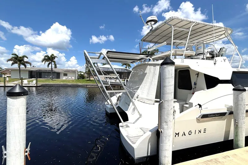 Slide: The Image of Fountaine Pajot Maryland 37 yacht docked by palm trees, clear sky, and calm water. - 5