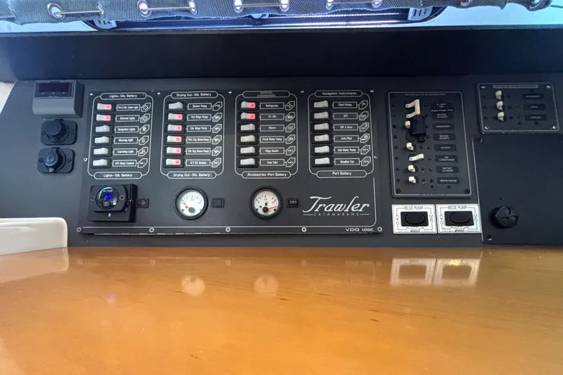 Slide: The Image of Control panel of a 2000 Fountaine Pajot Maryland 37 catamaran, featuring various switches and gauges. - 51