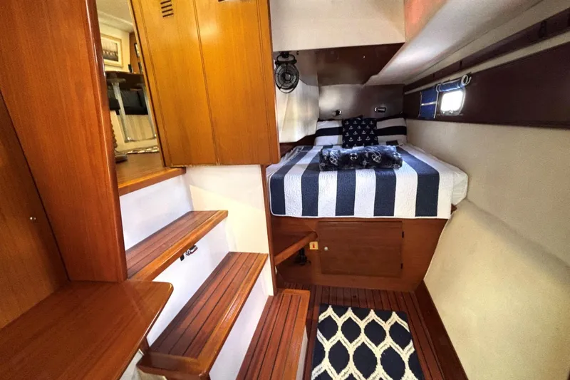 Slide: The Image of Cozy cabin interior of 2000 Fountaine Pajot Maryland 37 with striped bedding and wooden accents. - 61