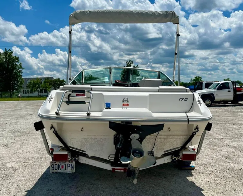 Slide: The Image of 1993 Sea Ray 170 BRLTD boat with canopy, parked on gravel under a cloudy sky. - 12