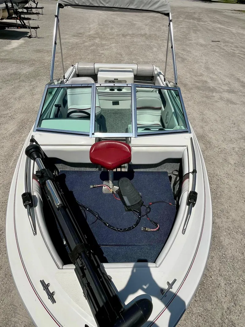 Slide: The Image of 1993 Sea Ray 170 BRLTD boat with red seat and windshield, parked on gravel. - 3