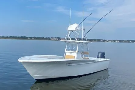 Slide: The Image of Custom Carolina Forbes 2025 boat on calm water with fishing rods and clear sky. - 1