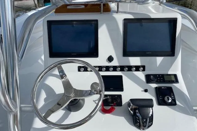 Slide: The Image of 2025 Custom Carolina Forbes boat dashboard with dual Garmin displays and steering wheel. - 10