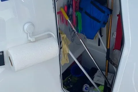 Slide: The Image of Storage compartment with electronic equipment on a 2025 Custom Carolina Forbes boat. - 12