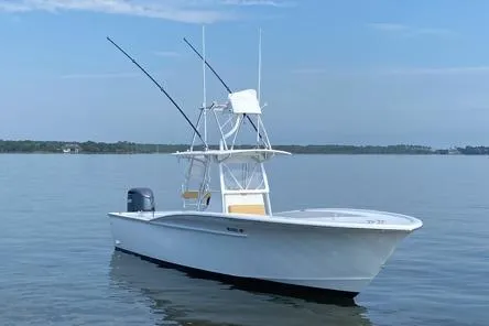 Slide: The Image of Custom Carolina Forbes 2025 boat on calm water with fishing rods and clear sky. - 2