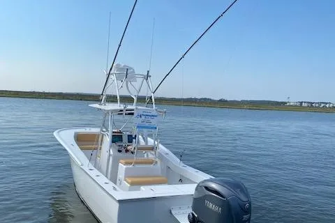 Slide: The Image of Custom Carolina Forbes 2025 boat cruising on water near coastal homes. - 24