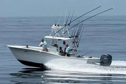 Slide: The Image of Custom Carolina Forbes 2025 boat with fishing rods on calm water, featuring Yamaha outboard motor. - 5