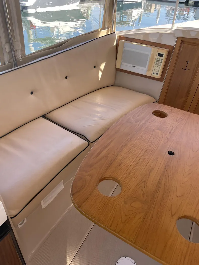 Slide: The Image of Interior of 2008 Duffy Cuddy 22 boat with beige seating and wooden table. - 3
