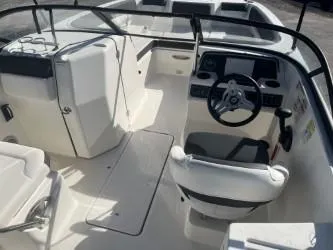 Slide: The Image of 2021 Bayliner DX 2200 boat interior with steering wheel and seating. - 8