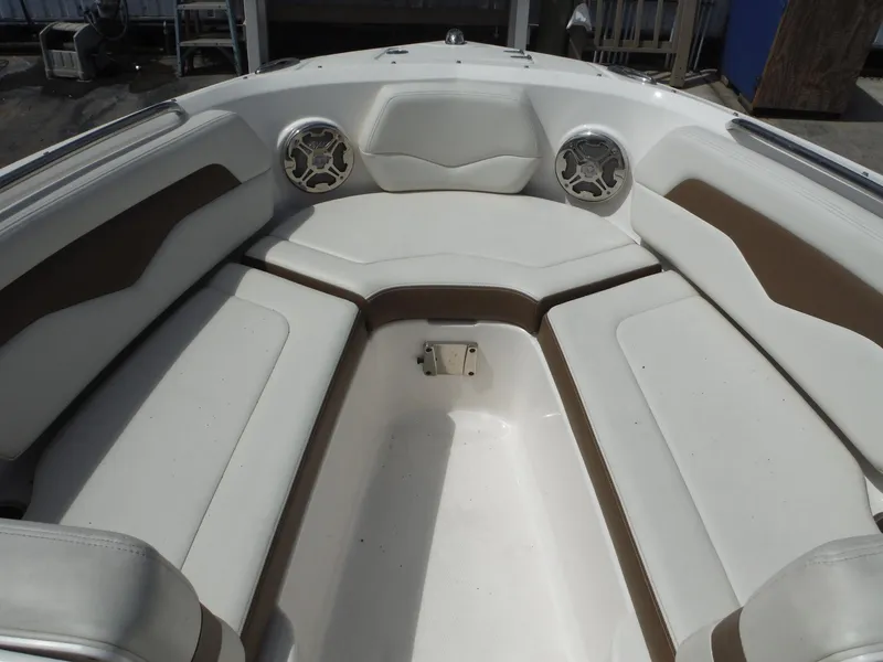 Slide: The Image of 2015 Chaparral 226 SSi boat interior with white and brown seating and speakers. - 15