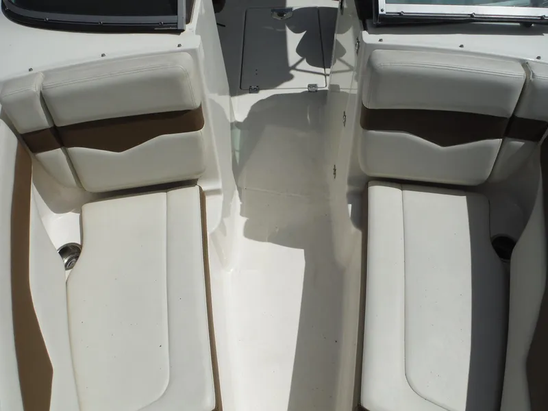 Slide: The Image of Interior seating of 2015 Chaparral 226 SSi boat, featuring white and brown cushioned seats. - 19