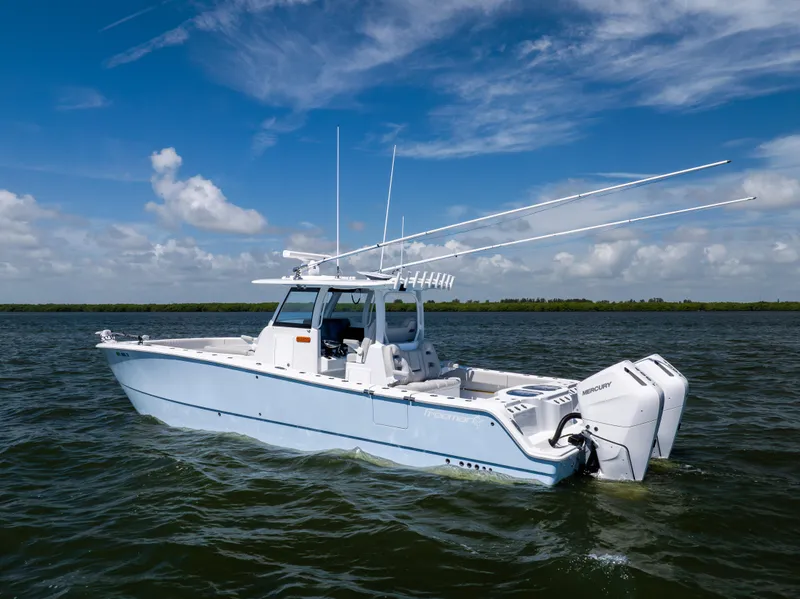 Slide: The Image of 2024 Freeman 35 boat on water with dual Mercury engines under a clear blue sky. - 16
