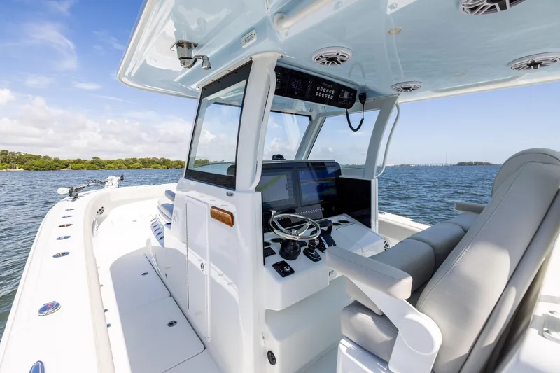 Slide: The Image of 2024 Freeman 35 boat interior with modern helm, steering wheel, and navigation screens on open water. - 41