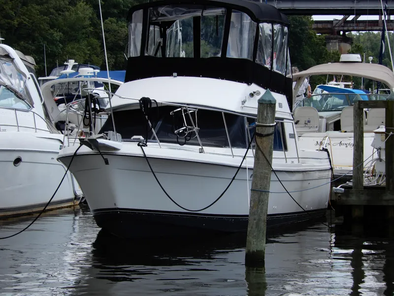 The Image of 1987 Carver 28 Mariner Voyager docked at marina, surrounded by other boats. - 0