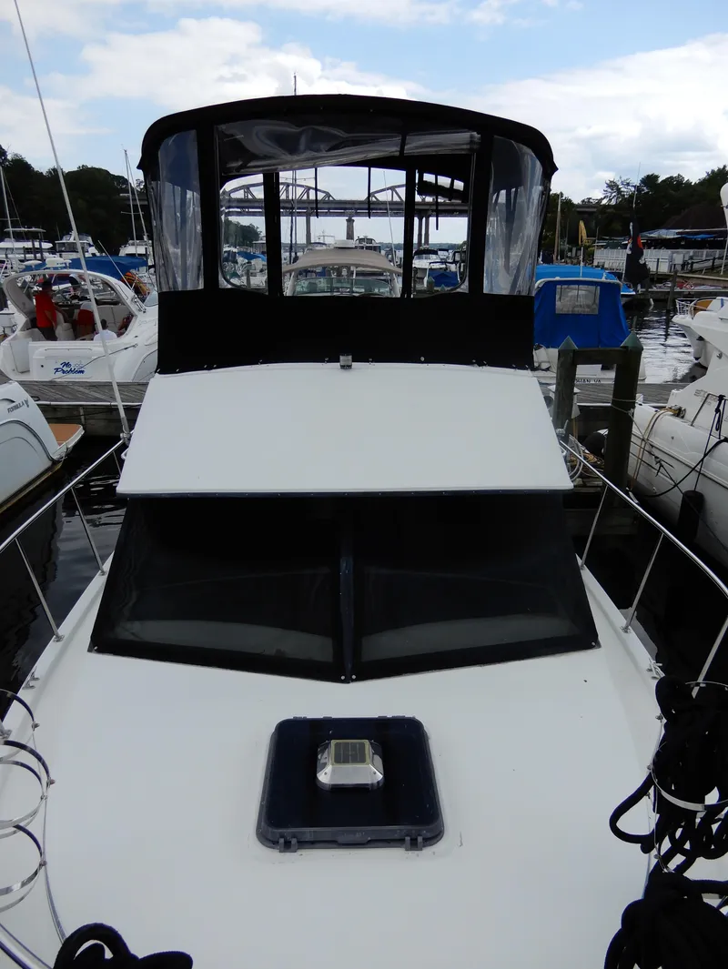 Slide: The Image of 1987 Carver 28 Mariner/Voyager boat docked at a marina, featuring a covered helm. - 12