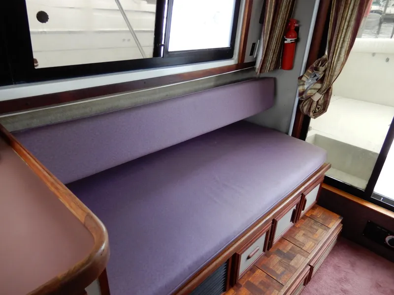 Slide: The Image of Interior of 1987 Carver 28 Mariner with purple seating and wooden storage drawers. - 27