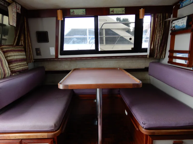 Slide: The Image of Interior of 1987 Carver 28 Mariner Voyager with dining area and purple seating. - 28