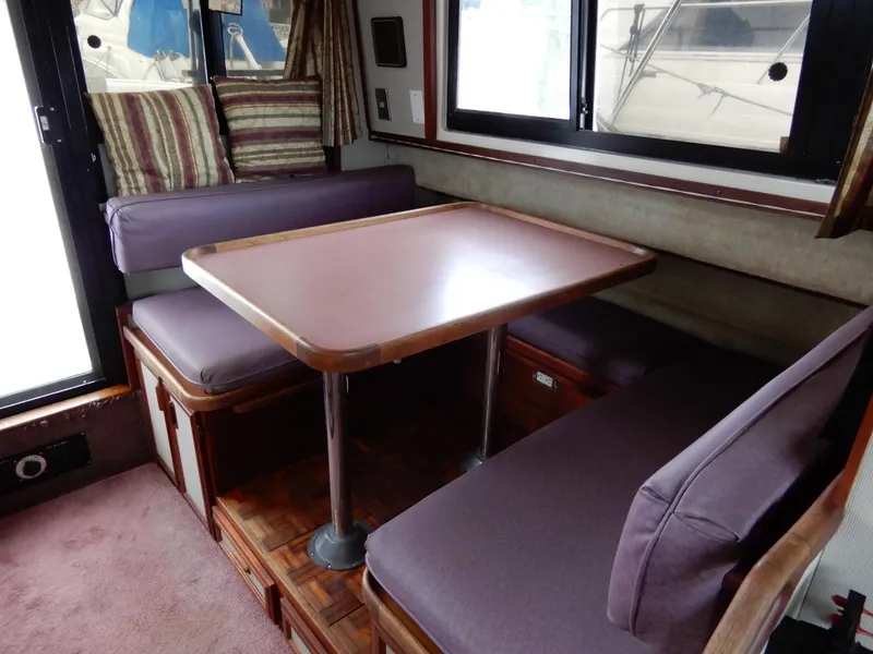 Slide: The Image of Interior of 1987 Carver 28 Mariner Voyager with dining area and cushioned seating. - 29