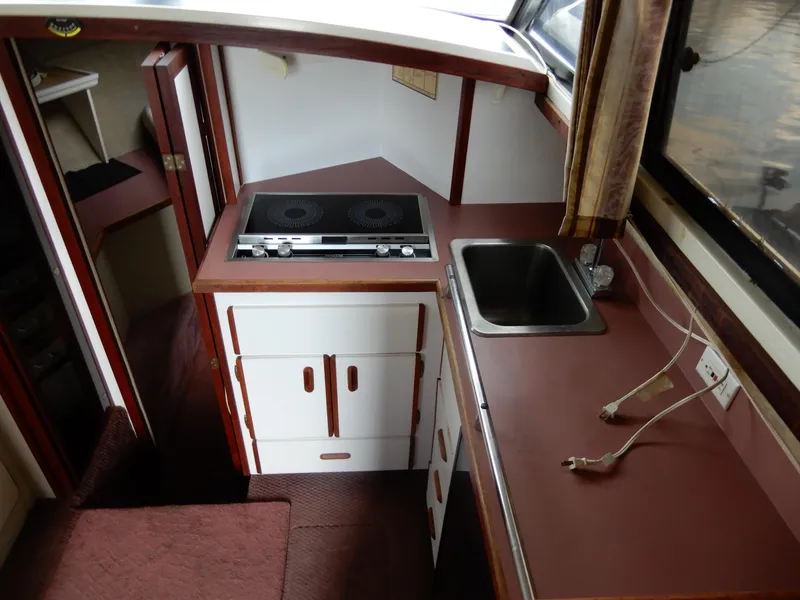 Slide: The Image of 1987 Carver 28 Mariner Voyager kitchen with stove, sink, and cabinetry. - 33