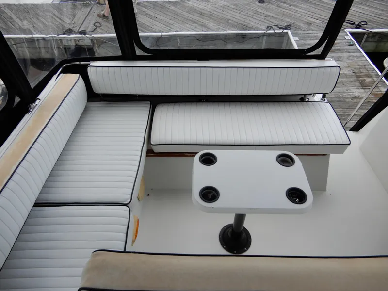 Slide: The Image of 1987 Carver 28 Mariner Voyager interior with white cushioned seating and table. - 17