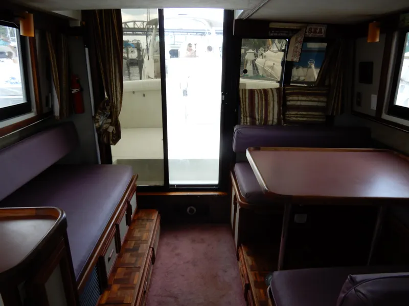 Slide: The Image of Interior of 1987 Carver 28 Mariner/Voyager with seating and table, featuring wood accents. - 25