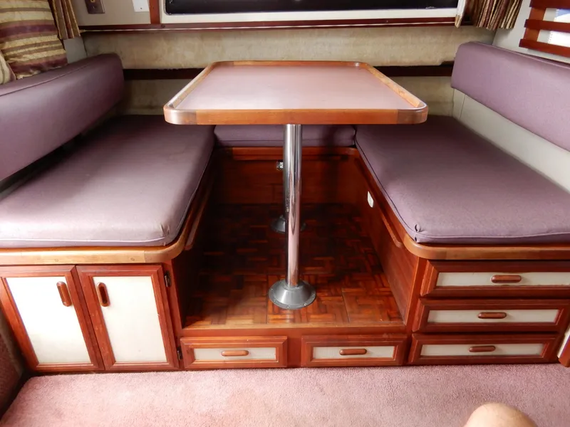Slide: The Image of Interior of 1987 Carver 28 Mariner with wooden table and cushioned seating. - 30