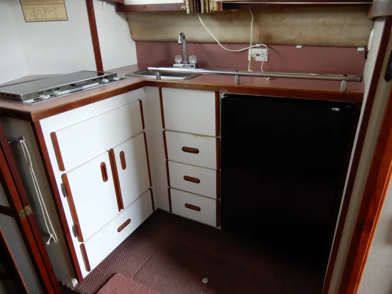 Slide: The Image of 1987 Carver 28 Mariner Voyager kitchen with stove, sink, and refrigerator. - 34