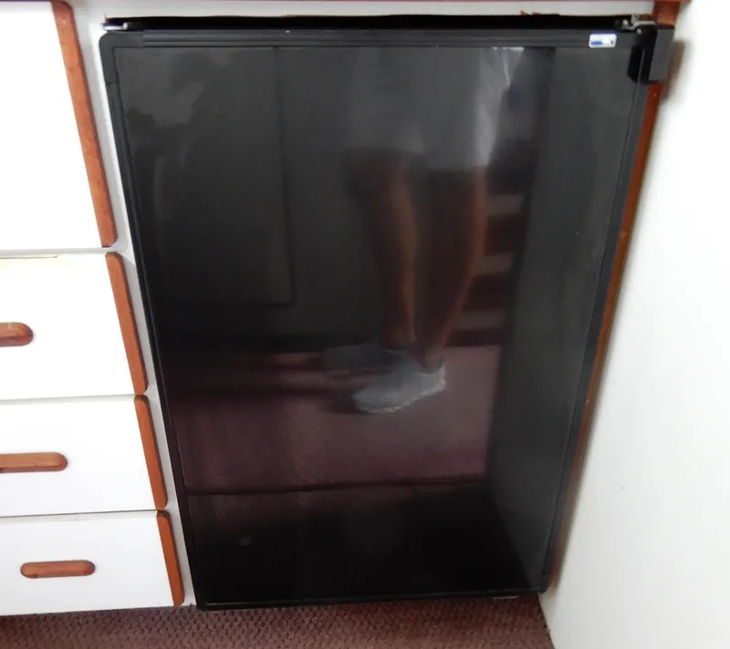 Slide: The Image of 1987 Carver 28 Mariner/Voyager interior with black refrigerator and white cabinetry. - 35
