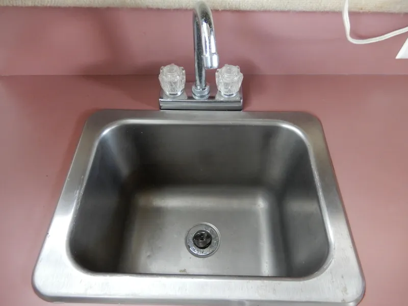 Slide: The Image of Stainless steel sink with dual-handle faucet on pink countertop, Carver 28 Mariner 1987 model. - 38