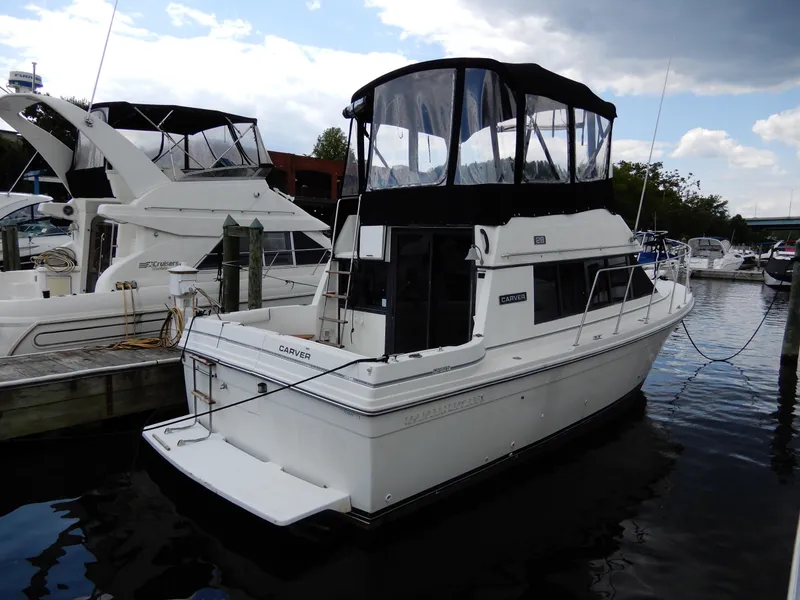 Slide: The Image of 1987 Carver 28 Mariner/Voyager docked at marina, featuring a white hull and black canopy. - 4