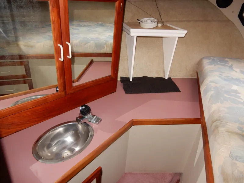 Slide: The Image of 1987 Carver 28 Mariner Voyager cabin interior with sink, mirror, and bed. - 42