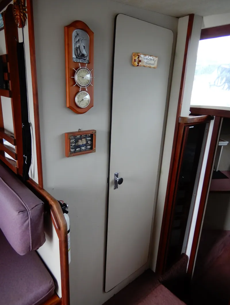Slide: The Image of Interior of 1987 Carver 28 Mariner with nautical decor and cabin door. - 43