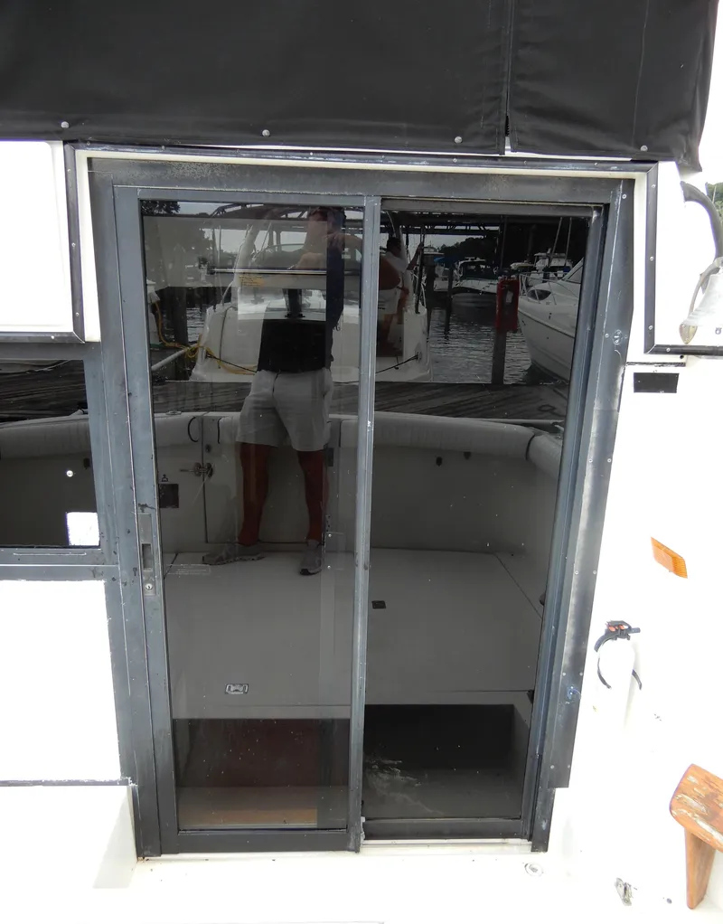 Slide: The Image of 1987 Carver 28 Mariner/Voyager boat with sliding glass door and dock reflection. - 8
