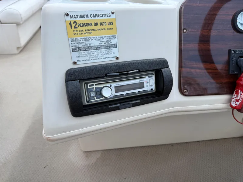 Slide: The Image of Console of a 2000 Harris 200 Super Sunliner boat with capacity label and stereo system. - 14