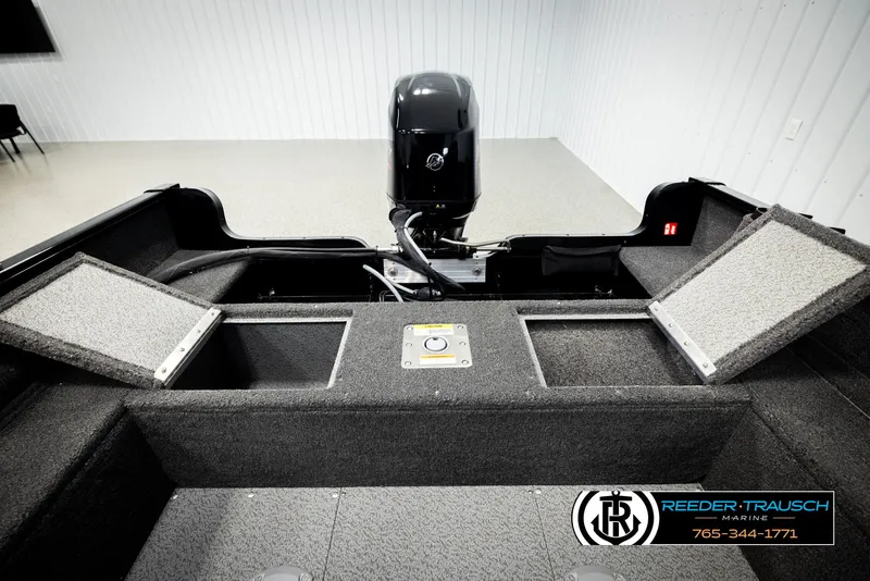 Slide: The Image of 2026 Lund 1650 Rebel XL SS boat interior with storage compartments and motor. - 19